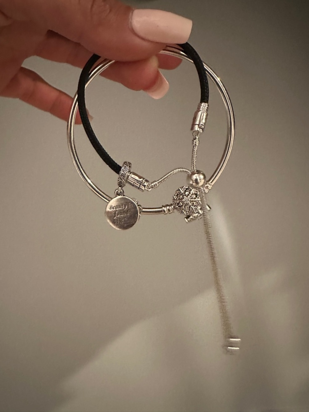 Pandora bangle and black rubber Bracelet with Disney belle inspired charms.